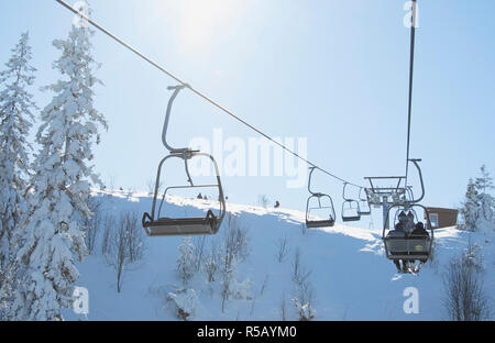 Skiers on lift in mountains. A close up Stock Photo