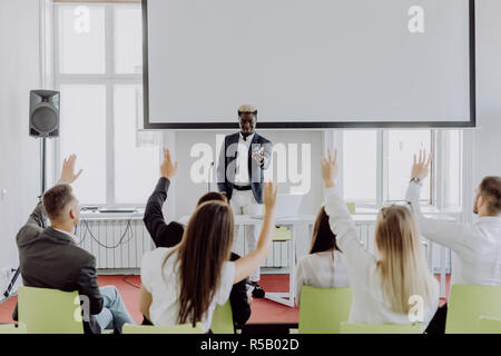 African american businessman giving presentation discussing project with multi-ethnic group at corporate training, black teaching coach answering ques Stock Photo