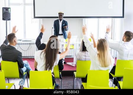 Group of business people raise hands up to agree with speaker in the meeting room seminar Stock Photo
