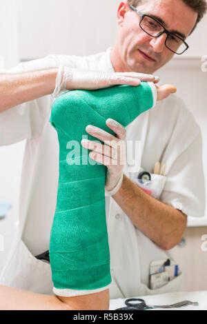 Doctor placing a plaster , emergency department of a private hospital . Stock Photo