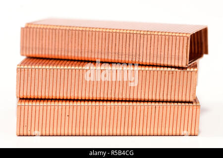 Metal staples of copper for stapler, in insulation with white background. Close up. Macro. selective focus Stock Photo