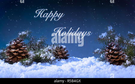 Holiday winter night scene with pine cones and evergreen tree branches on snow against a dark sky with stars Stock Photo