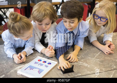 Little children businessmen sharing ideas in office. Stock Photo