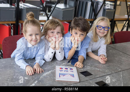 Little children businessmen sharing ideas in office. Stock Photo