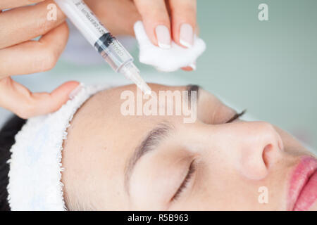 Doctor applying a facial treatment using a syringe Stock Photo