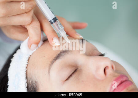 Doctor applying a facial treatment using a syringe Stock Photo