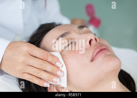 Doctor cleaning a woman patient face Stock Photo