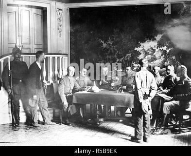 In the hands of the Germans. This remarkable picture, the first ever published of a German military court in France, shows a French peasants on trial for having been found with a rifle. Beside the sentry stands a witness. The court room is a French chateau. Note the tapestry behind the German officers. ca. 1918 Stock Photo