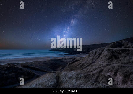 Stunning vibrant Milky Way composite image over landscape of Freshwater West beach in Pembrokeshire Wales Stock Photo