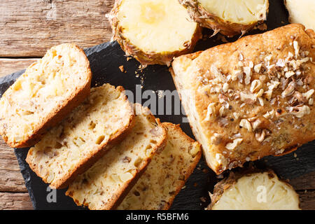Fruit bread with pineapples, walnuts and raisins close-up on the table. Horizontal top view from above Stock Photo
