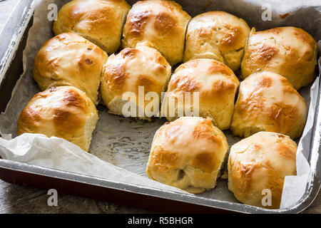 Traditional Easter hot cross buns in a oven plate on wooden table Stock Photo