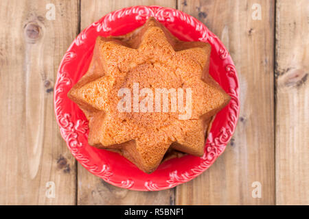Traditional Italian Christmas fruit cake Panettone Pandoro with festive red ribbon and Christmas decorations. On a wooden background. Free space for t Stock Photo