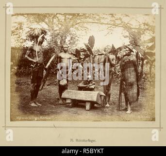 Five Zande (Makaraka) men standing around a buffalo-shaped wooden slit gong. Two of the men are holding fringed, wicker-work shields. One is holding a curved throwing knife, and has a large feather headdress. Die oberen Nil-LaÌˆnder. Volkstypen und Landschaften. Dargestellt in 160 Photographien. Nach der Natur aufgenommen von R. Buchta. Mit einer Einleitung von Dr. Robert Hartmann. Berlin, 1881. Source: 1789.a.13 plate 76. Language: German. Author: Buchta, Richard. Stock Photo