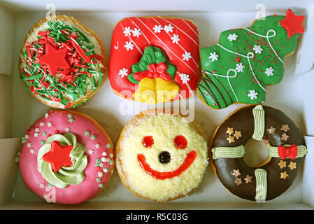 Box Filled with Colorful Christmas and Festive Decorated Doughnuts Sweets Stock Photo
