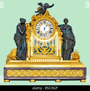 Antique golden mantel clock with cupid and ladies statuettes, on isolated green background with clipping path. Stock Photo