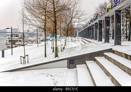 Rotterdam, The Netherlands, March 3, 2018: view of the grass lawns and cobble quay of Boompjes promenade covered with snow on a cold winter day Stock Photo