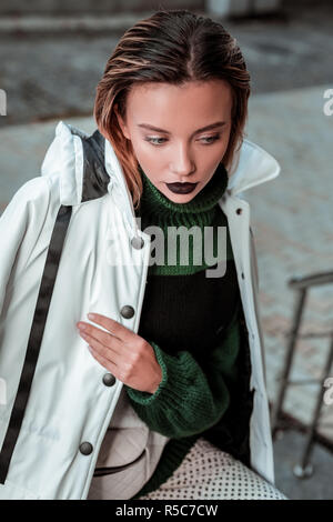 Winter jacket. Appealing blonde-haired fashionable photo model posing in white winter jacket Stock Photo