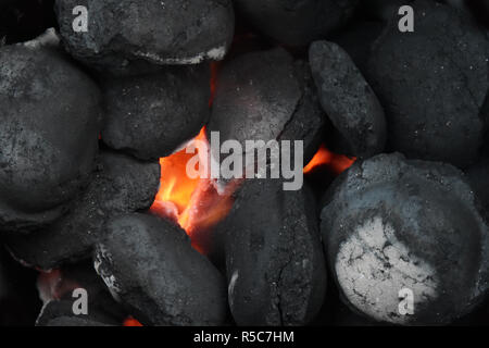 glowing charcoal briquettes in a barbecue grill, close up, background with copy space, selected focus Stock Photo