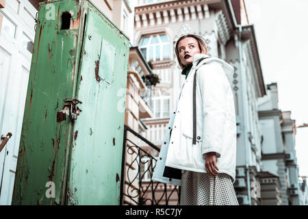 Posing in street. Slim appealing blonde-haired photo model posing in winter clothes in the street Stock Photo