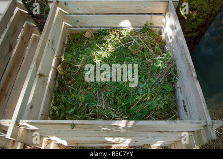 compost bin of wood filled with weeds from the garden Stock Photo