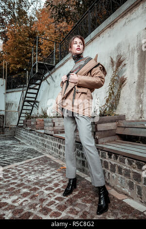 Fashionable woman. Stylish fashionable red-haired woman wearing grey trousers and high-heeled boots Stock Photo