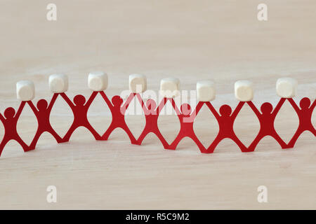 Paper people chain holding blank wooden cubes Stock Photo