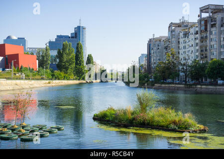 Dambovita river in downtown Bucharest; residential and office buildings on its shoreline, Romania Stock Photo