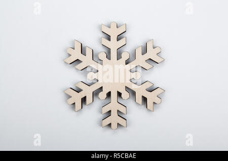 wooden snowflake as a symbol of winter on a gray background top view Stock Photo
