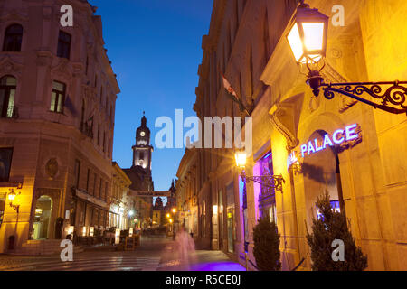 Kiraly utca and Town Hall illuminated at dusk, Pecs, Hungary Stock Photo