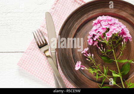 Spring table settings with fresh flower, napkin and silverware. Holidays background. Selective Focus. Stock Photo