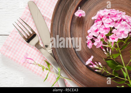 Spring table settings with fresh flower, napkin and silverware. Holidays background. Selective Focus. Stock Photo