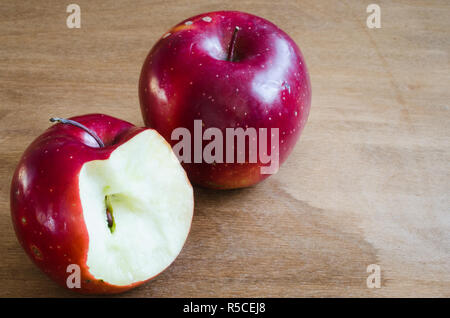 Fresh organic whole and bitten off apples on rustic wooden background. Selective Focus. Rustic style. Stock Photo