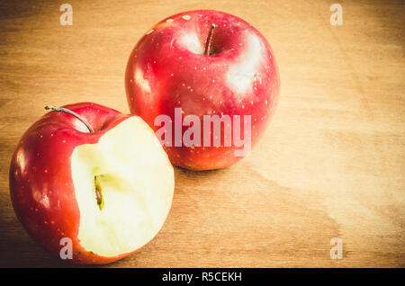 Fresh organic whole and bitten off apples on rustic wooden background. Selective Focus. Rustic style. Toned image. Stock Photo