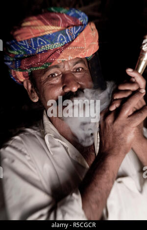 Indian man (member of Bishnoi religous sect) smoking a pipe, nr Jodhpur, Rajasthan, India Stock Photo