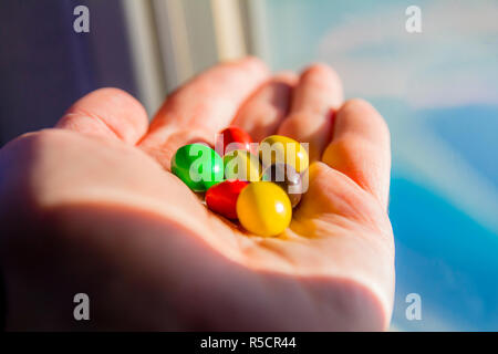 Man hand holding colorful chocolate candies buttons Stock Photo