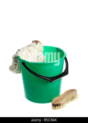 Green plastic bucket with a floorcloth hanging on its rim with a scrub brush near by isolated on white background. Stock Photo