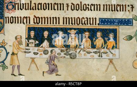 [Lower margin] Sir Geoffrey Luttrell is seated in the centre of a long table supported on two trestles, behind is a blue hanging with the Luttrell martlets in silver. On his left, his wife, Agnes Sutton, and two Dominicans, perhaps his chaplain, Robert of Wilford, and his confessor, William of Foderingeye. On Luttrell's right, two men and a lady. A bearded servant brings two dishes, and a cup-bearer kneels, having given his cup to Sir Geoffrey. On the table are knives, spoons, dishes, and plates or trenchers of bread. Luttrell Psalter. England [East Anglia]; circa 1325-1335. Source: Add. 42130 Stock Photo