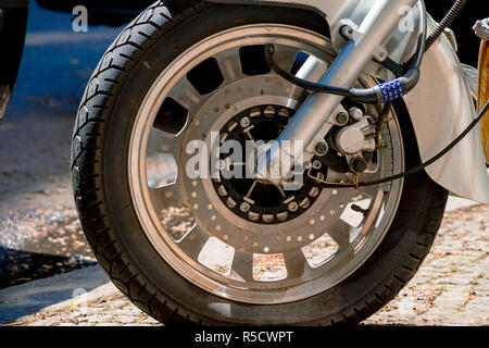 Security number padlock blocking motorcycle wheel on the street Stock Photo