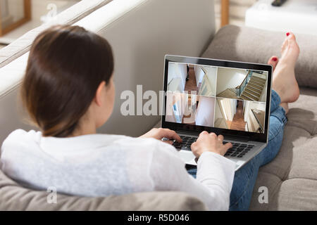Woman Monitoring CCTV Footage On Laptop Stock Photo