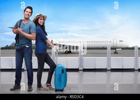 Portrait of asian tourist couple with backpack and suitcase standing Stock Photo