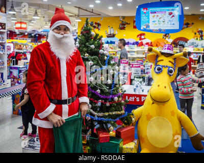 Bangkok, Thailand, 01 December, 2018. - A Thai man in Santa Claus outfit waits to hand out small gifts to shoppers at the Toys R Us store in Central World in Bangkok. Toys R Us closed all of their brick and mortar stores in the United States in 2018 but kept many of their overseas stores open. Credit: Jack Kurtz/ZUMA Wire/Alamy Live News Credit: ZUMA Press, Inc./Alamy Live News Stock Photo