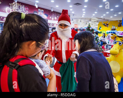 Bangkok, Thailand, 01 December, 2018. - A Thai man in Santa Claus outfit hands out small gifts to shoppers at the Toys R Us store in Central World in Bangkok. Toys R Us closed all of their brick and mortar stores in the United States in 2018 but kept many of their overseas stores open. Credit: Jack Kurtz/ZUMA Wire/Alamy Live News Stock Photo