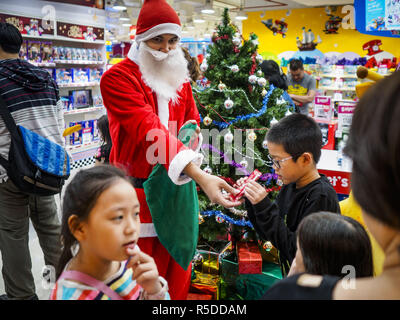 Bangkok, Thailand, 01 December, 2018. - A Thai man in Santa Claus outfit hands out small gifts to shoppers at the Toys R Us store in Central World in Bangkok. Toys R Us closed all of their brick and mortar stores in the United States in 2018 but kept many of their overseas stores open. Credit: Jack Kurtz/ZUMA Wire/Alamy Live News Stock Photo