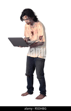 Creepy asian male zombie typing with laptop Stock Photo