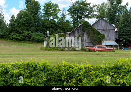 Abandoned Ford Mercury in field by barn. Stock Photo