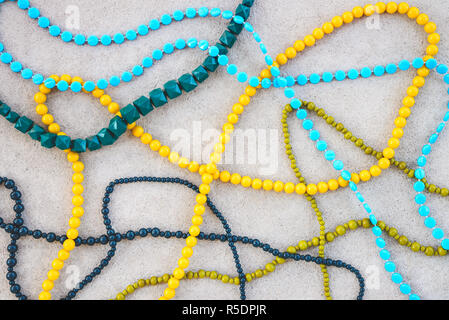 Retro style colorful necklaces on concrete surface. Fashion background. Stock Photo