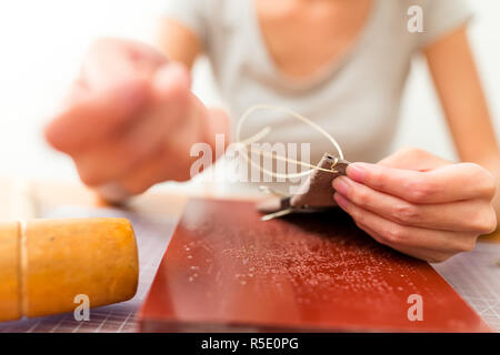 Leather handbag craftsman at work in a workshop Stock Photo