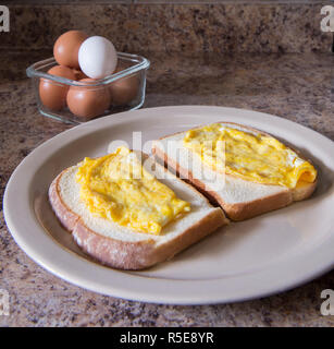 Scrambled eggs on two pieces of toast, as part of the morning breakfast Stock Photo