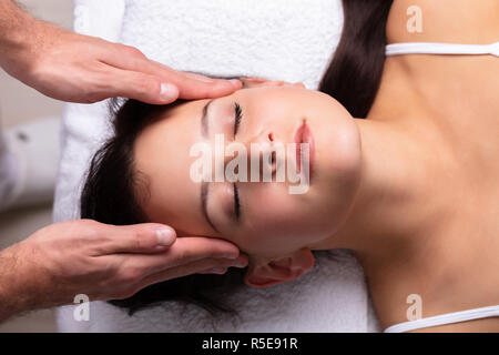 Close-up Of A Therapist Hand Massaging Young Woman's Head Stock Photo