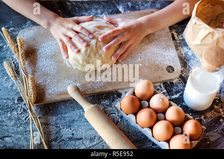 Knead the dough with wheat on a dark background Stock Photo